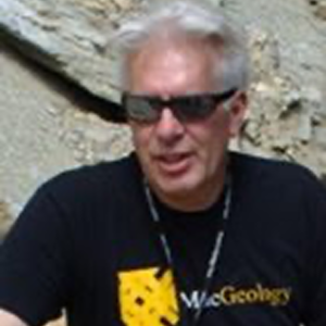 Professor Karl Wirth outdoors wearing sunglasses and a Macalester Geology T-shirt.