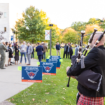 A bagpiper performs on the campus lawn as guests gather for Mac Fest 2025.