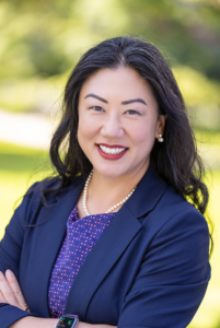 Kathryn Kay Coquemont, vice president for student affairs at Macalester College, smiles outdoors in professional attire.