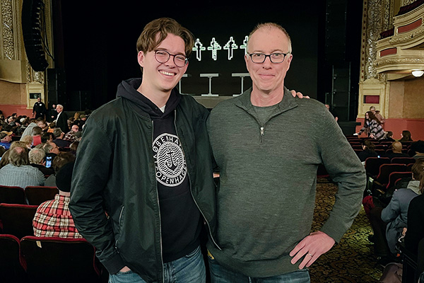 Owen and Grant Killoran stand in front of a stage at a concert