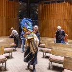 Macalester Rabbi Emma Kippley-Ogman holds the Torah with Rabbi Barry Cytron, the previous campus rabbi, looking on.
