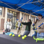 Two students play archery at a carnival game