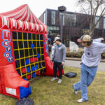 Two students play a large inflatable game of Connect 4