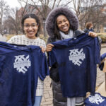 Two students hold up Founding Day jerseys