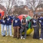 Group of six students and staff stand in front of a large inflatable ball