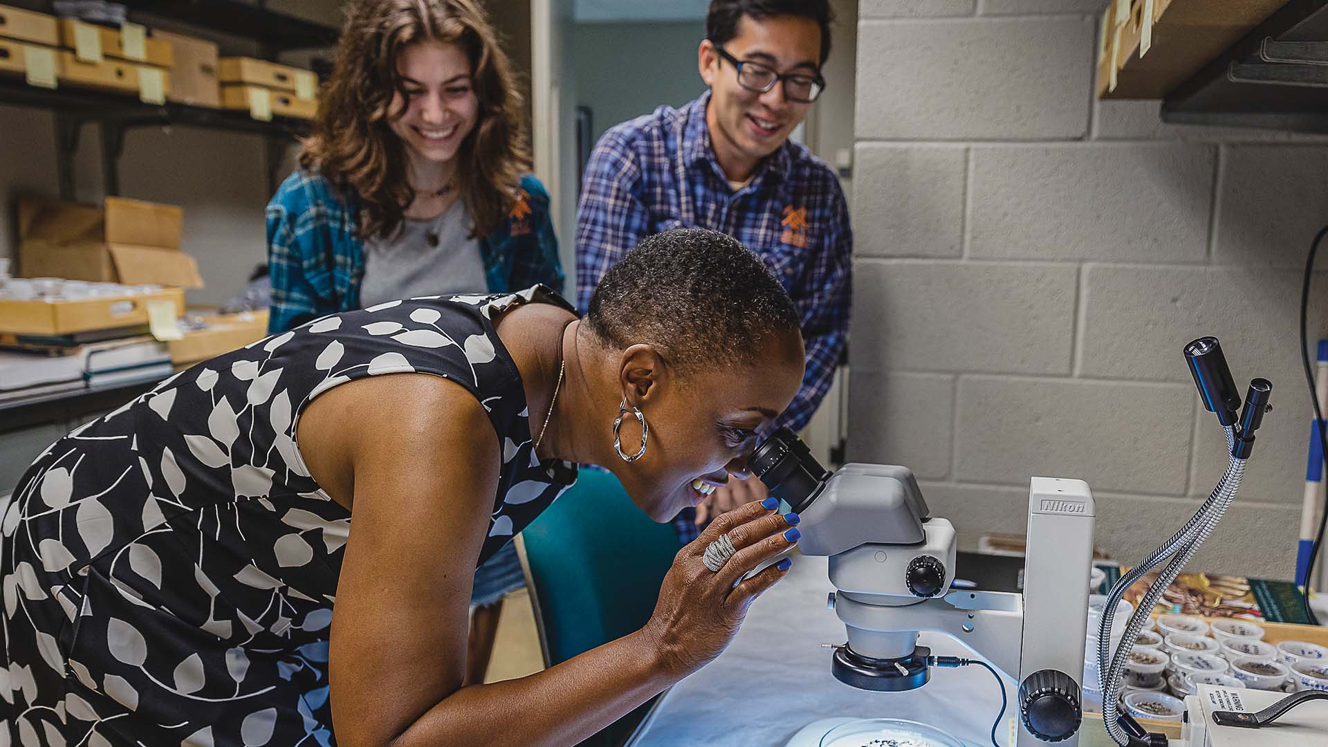 Provost Lisa Anderson-Levy looking into a microscope