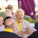 Alumni sitting at a table and smiling