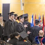 Graduating students get up from their seats as they prepare to receive their diplomas at Macalester's 2022 December Graduation.
