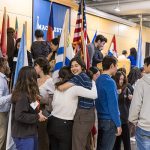 A group of students hug one another