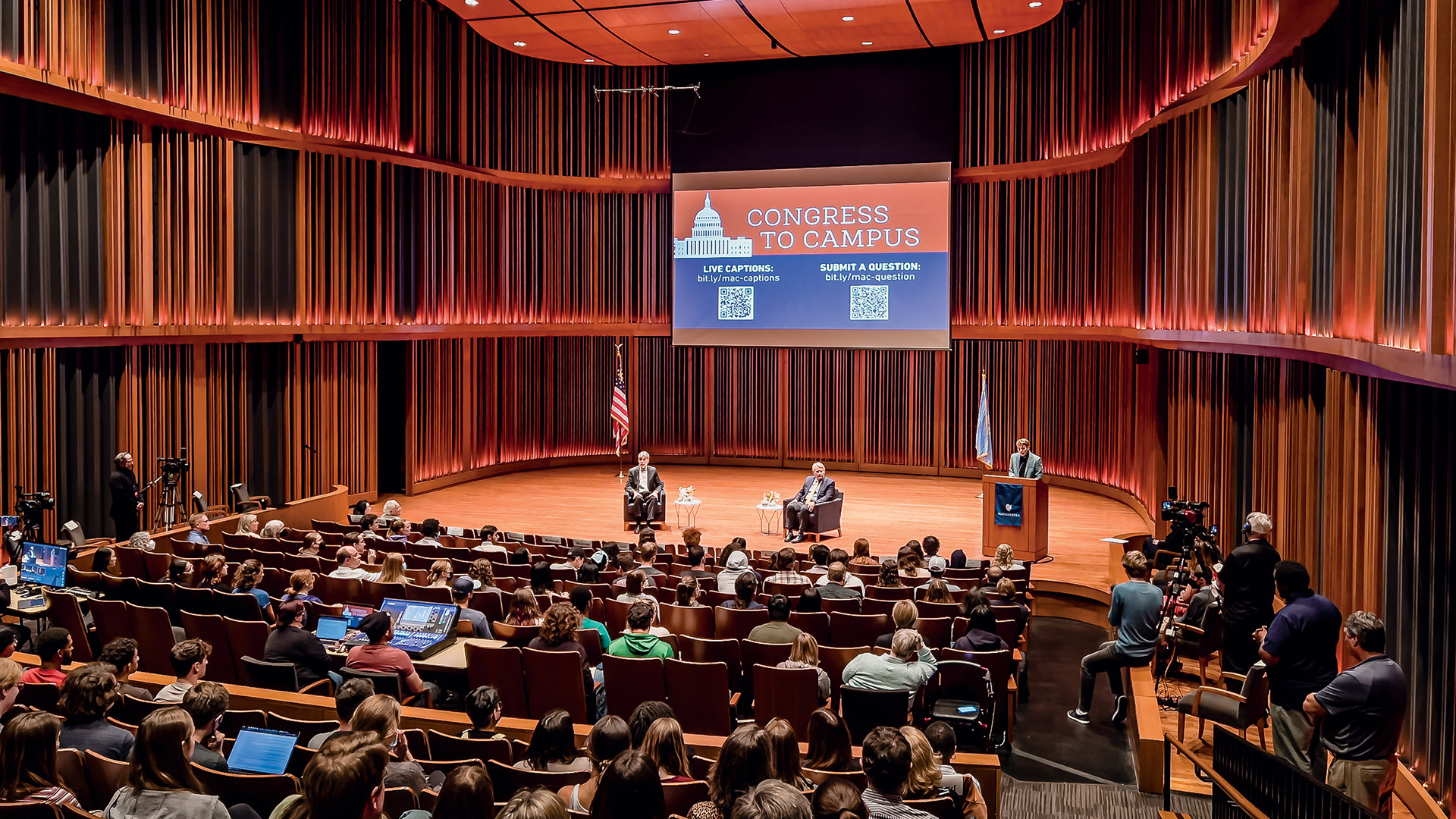 Congress to Campus speakers sitting on stage facing an audience in Mairs Concert Hall
