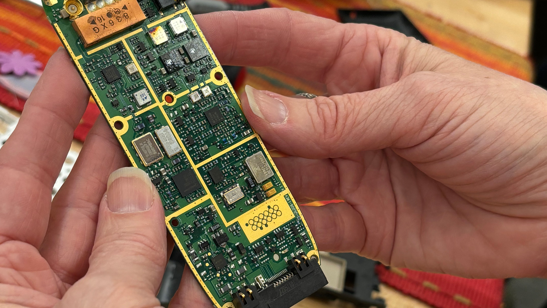 Two hands hold a computer battery