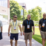 Four Reunion attendees walk down a path away from the Leonard Center