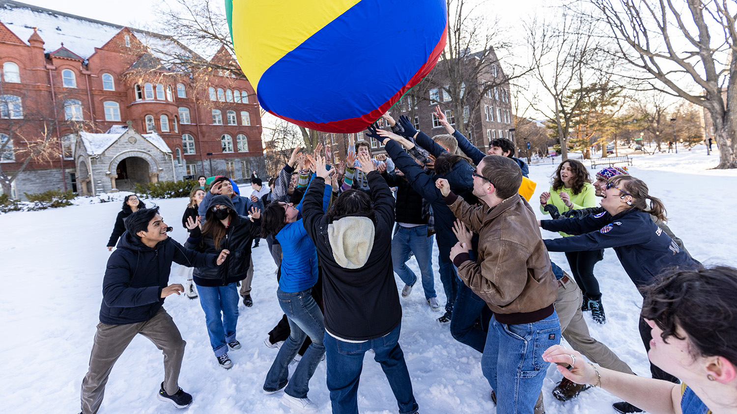 Students reach for the multicolored Pushball in the air.