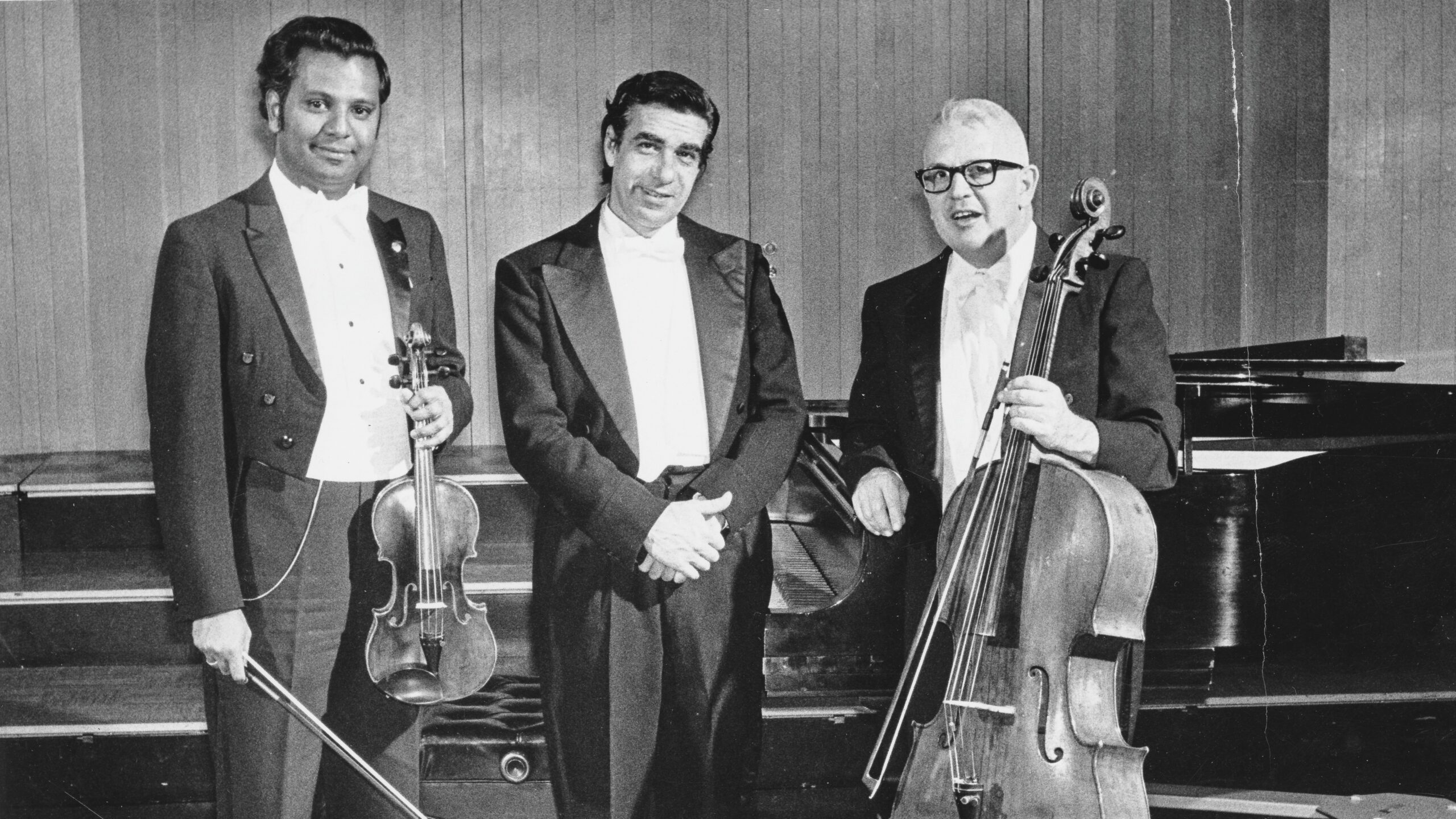 The Macalester Trio posing with their instruments in a concert hall.