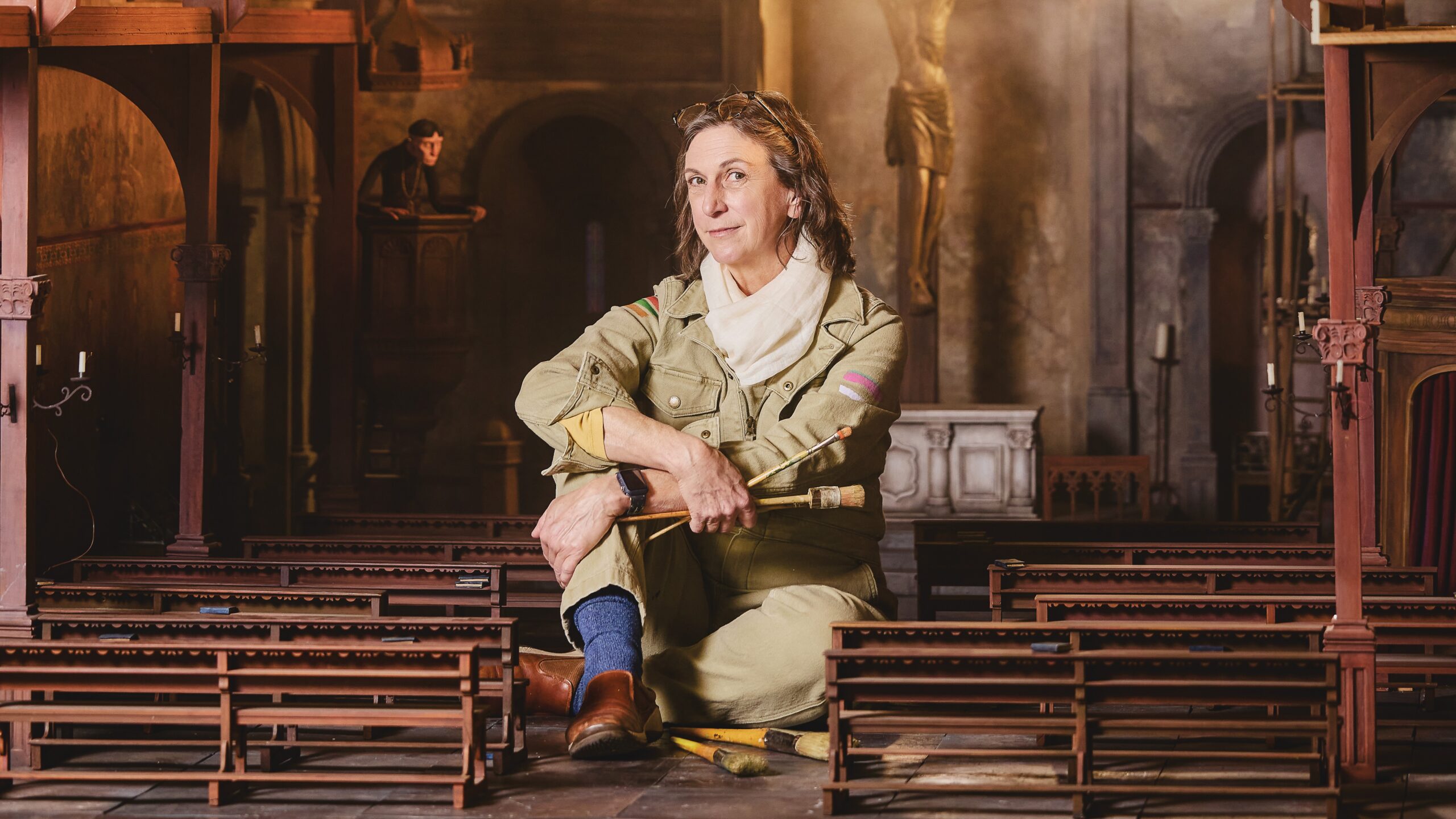 Scenic artist Polly Allen Robbins ’85 sits among detailed miniature set models used to design scenes for stop-motion films.