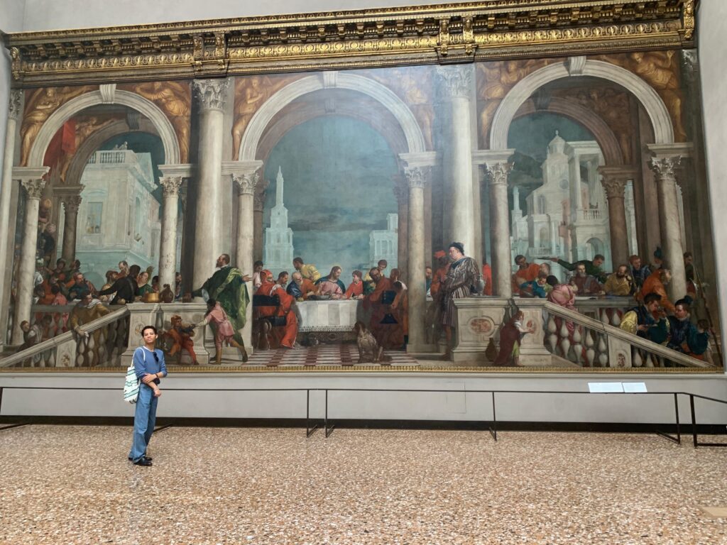 Ruben Verità ’26 poses in front of a piece of art in Venice's Gallerie dell'Accademia.