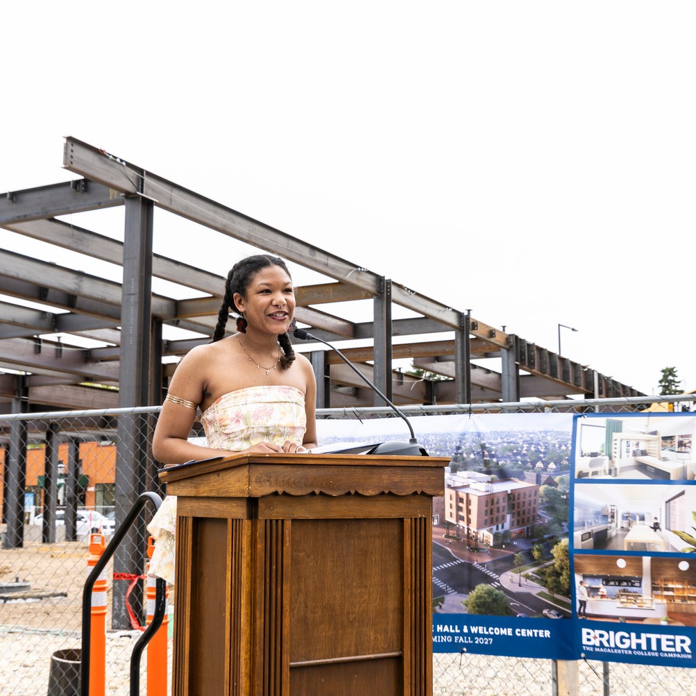 Student Corinne Byus speaking at a podium