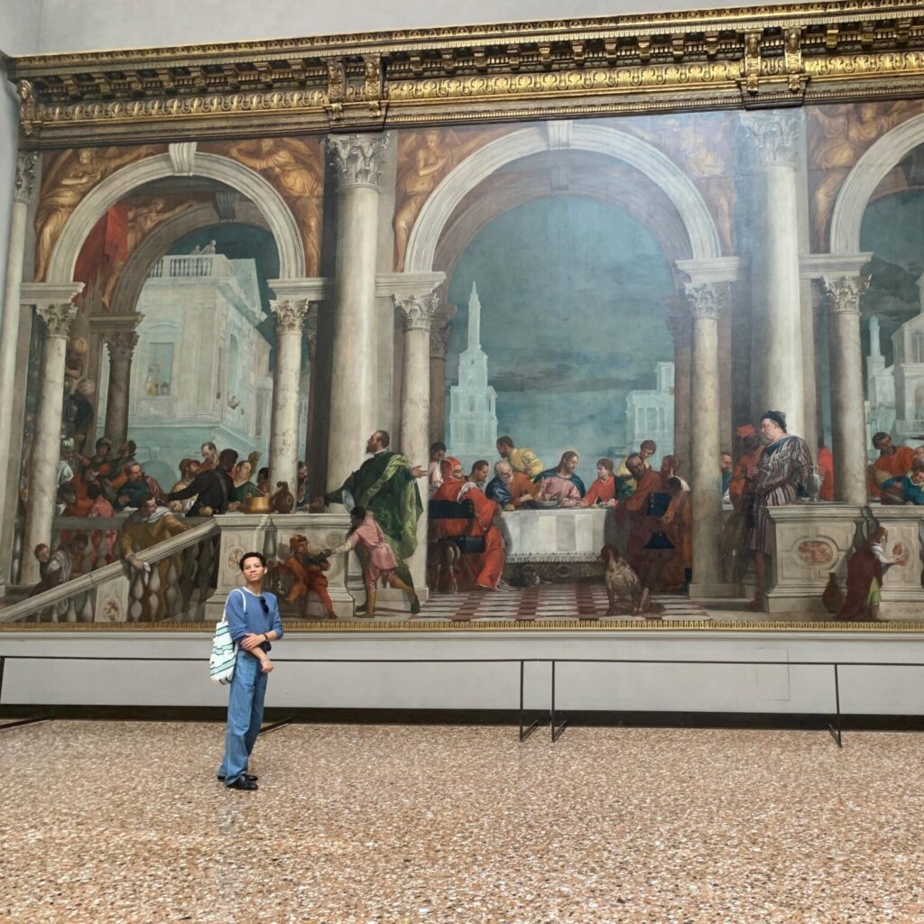 Ruben Verità ’26 poses in front of a piece of art in Venice's Gallerie dell'Accademia.