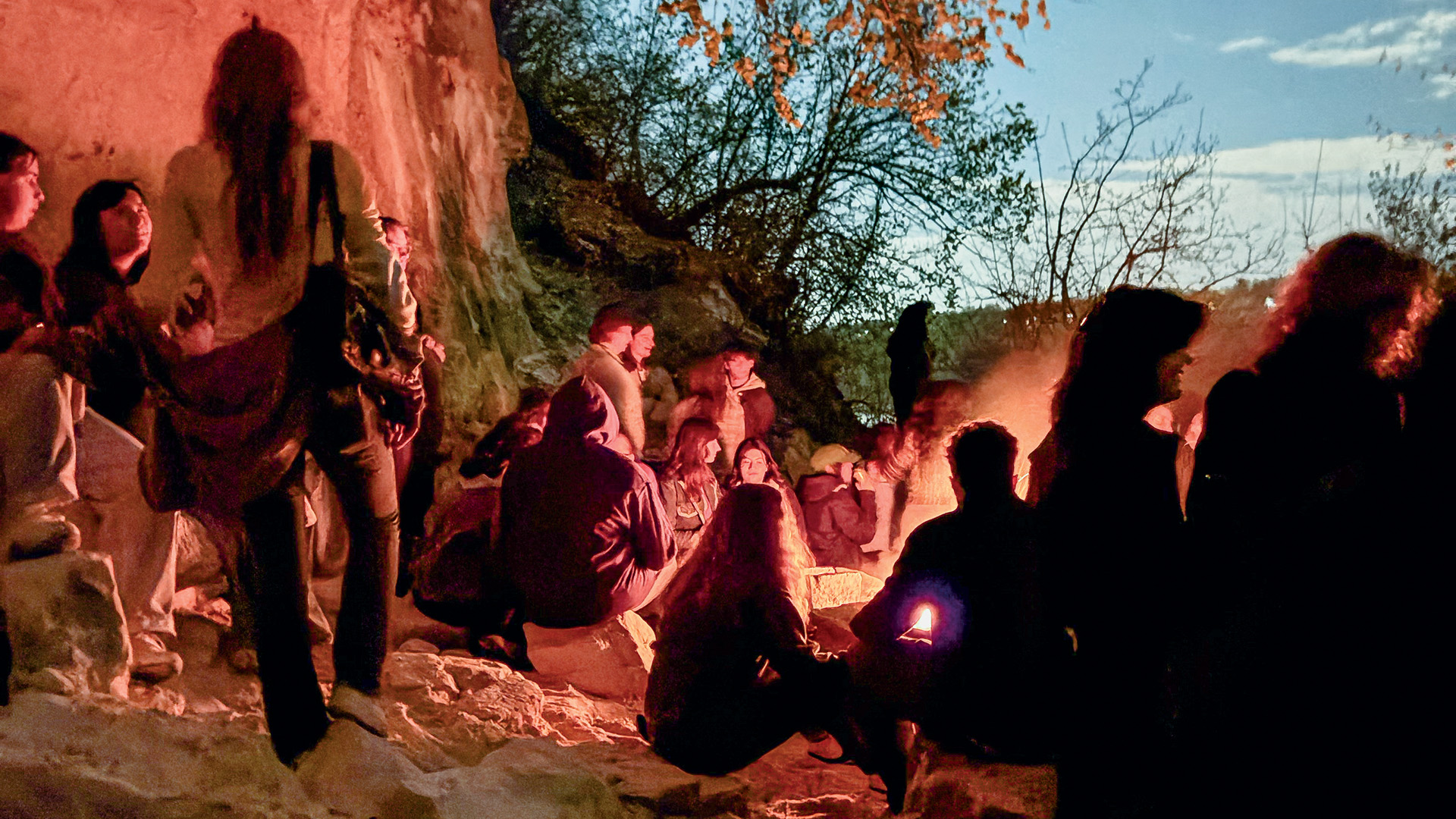 Group of students sitting around a bonfire