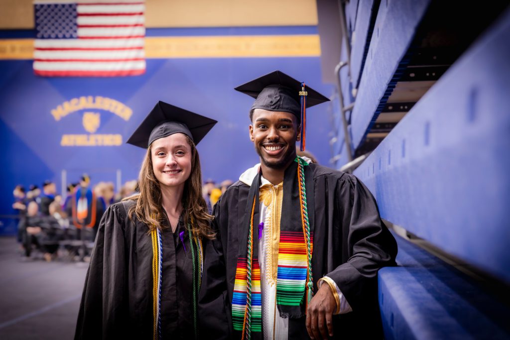 Two recent graduates pose for a picture at Commencement.