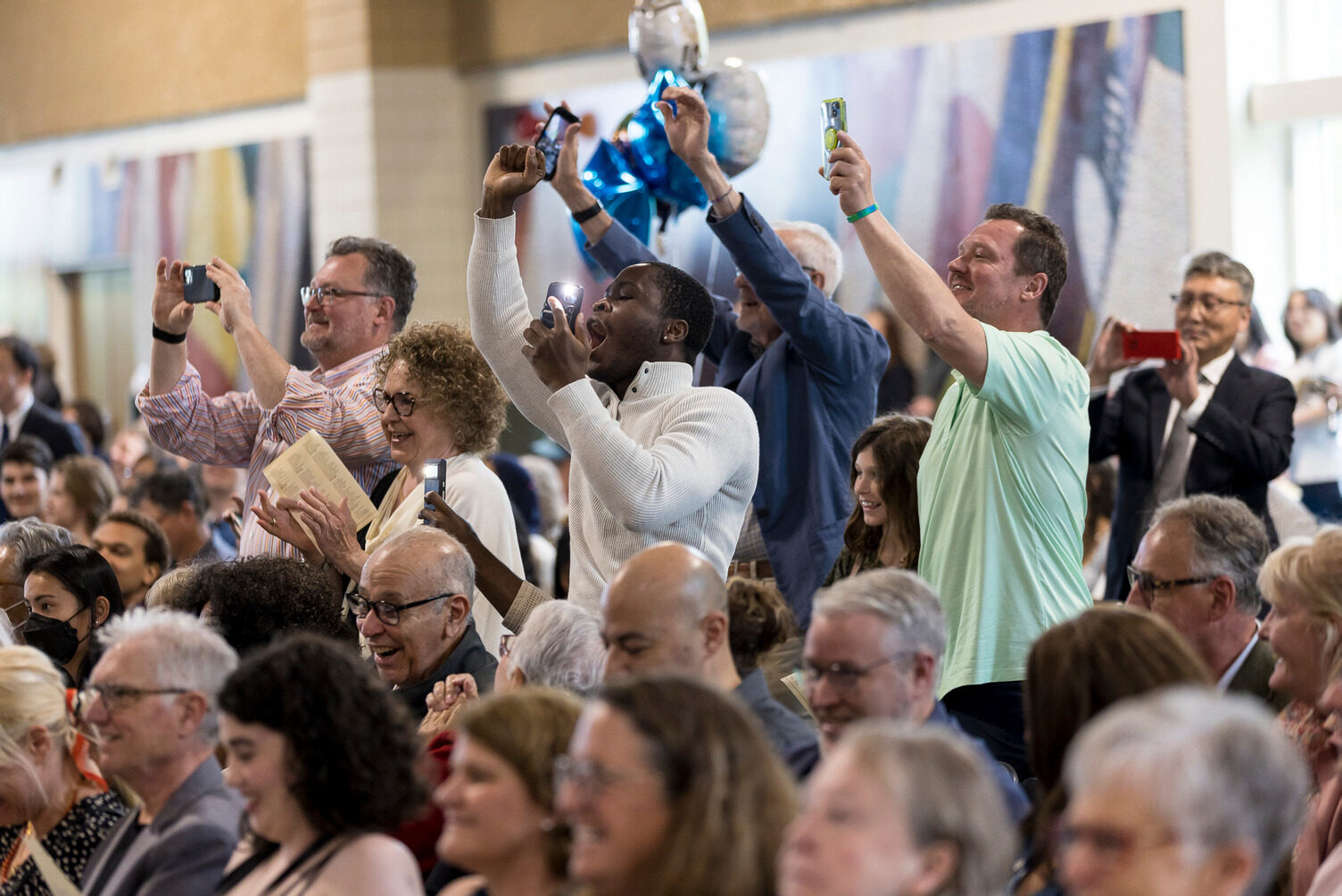 Parents cheering in the stands at Commencement.