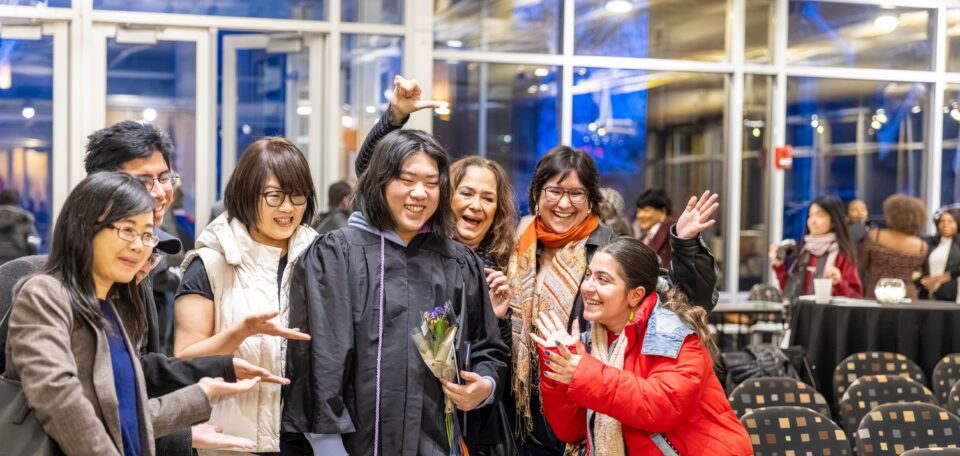 A family poses with a Macalester grad at December commencement.