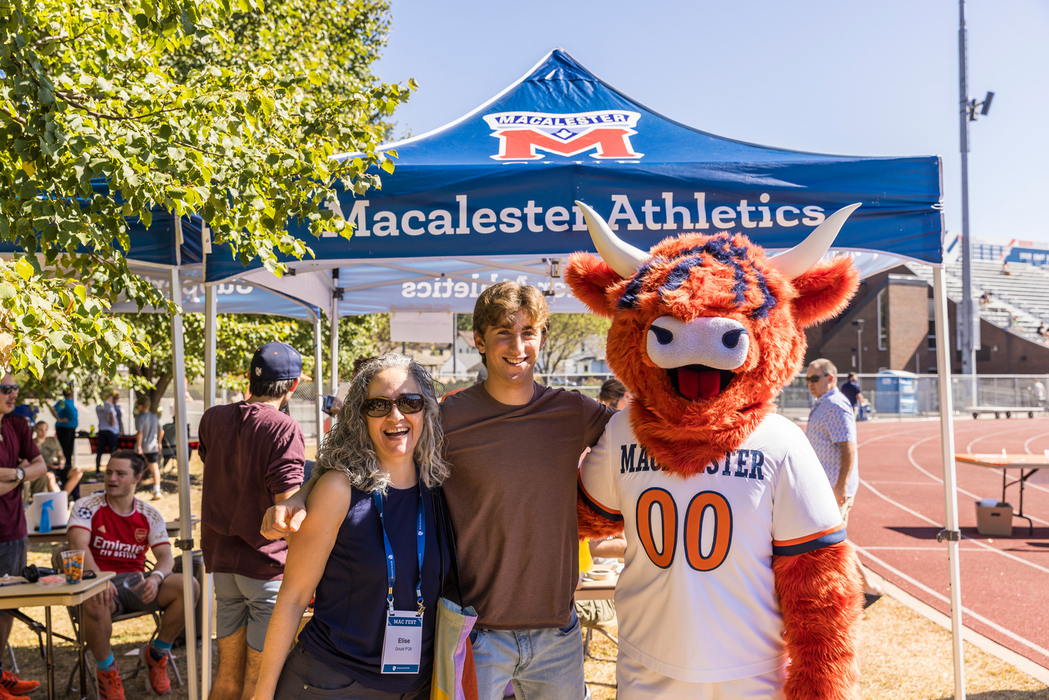 Coo poses with a Mac student and parent at an M Club event.