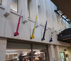 Photo of 4 colorful rockets mounted high on the wall of the hallway
