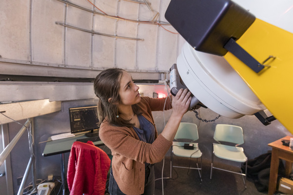 Student positions a large telescope