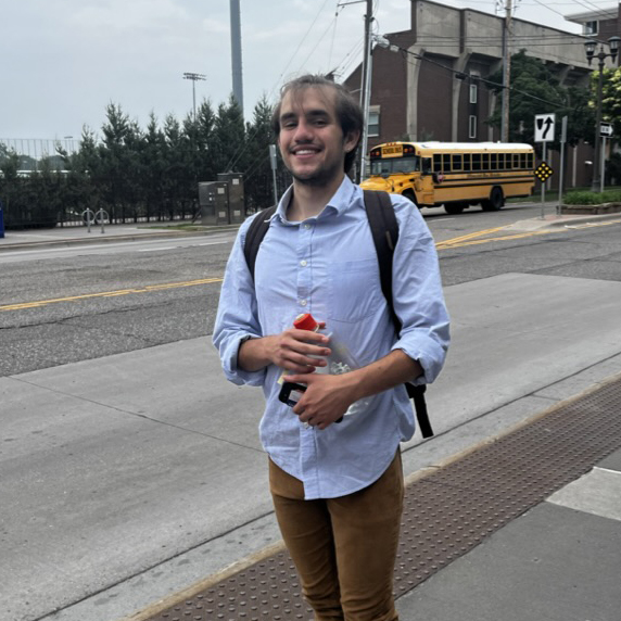 Photo of Alex Fendig standing on the street near the Macalester Stadium