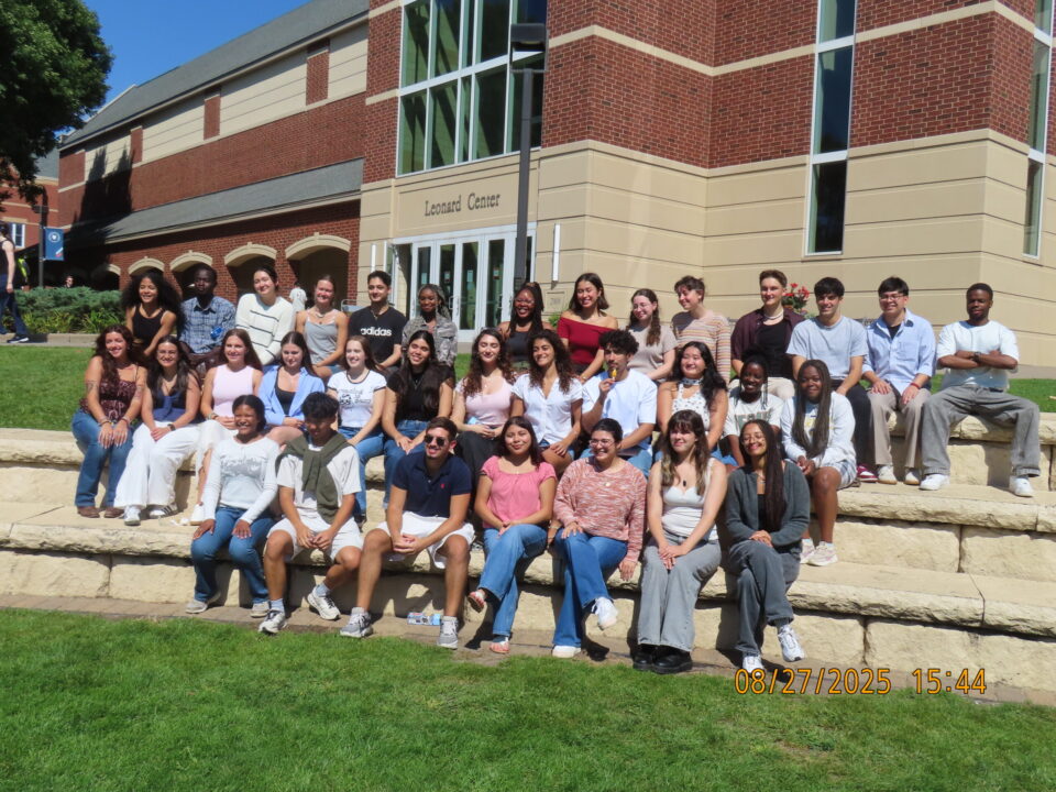 35 Resident Assistants sitting on steps outside a building.