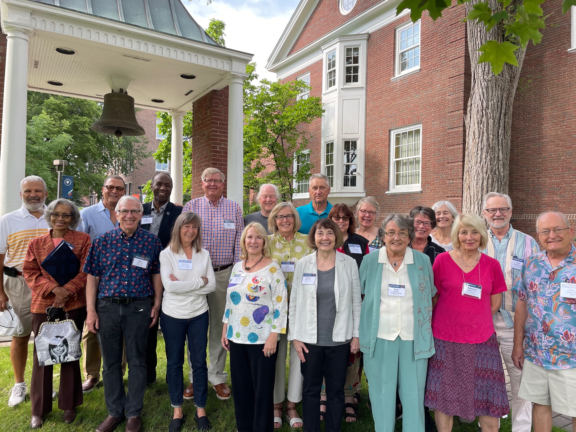 Photo of 1973 Reunion Planning Committee outside Weyerhaeuser Hall, Macalester College