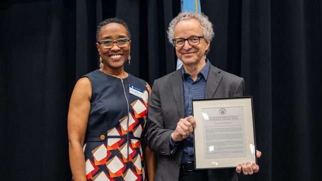 Provost Lisa Anderson-Levy poses with David Martyn as he holds his award citation