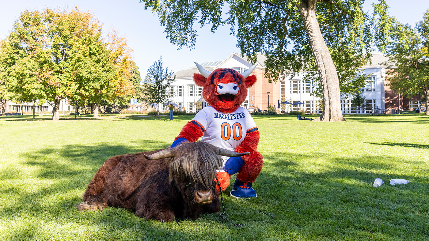 Coo, the college mascot, poses with a highland cow on the Great Lawn