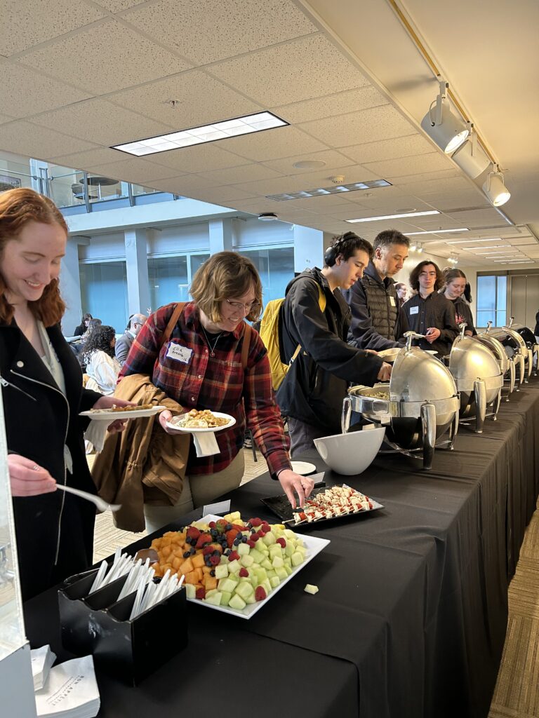 Guests take food from the buffet table in the Smail Gallery