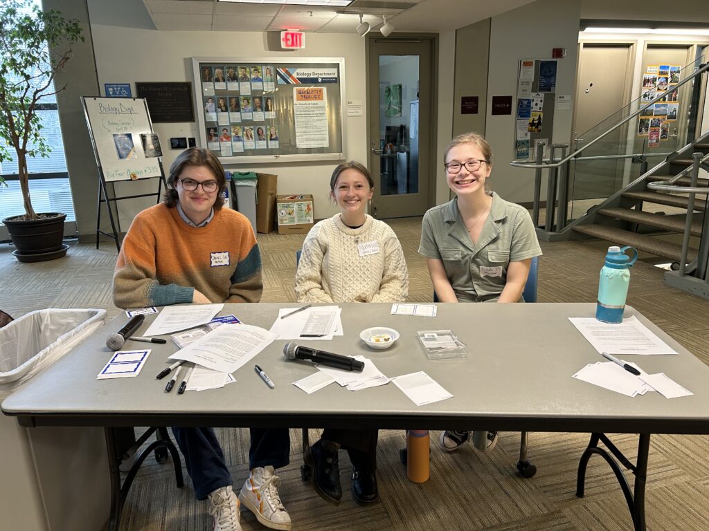 English Honor Society Officers Daniel Graham '26, Natalie Mazey '26 and Leah Wasson '25 greet guests at the check-in table for Apps & Alums in Olin Rice