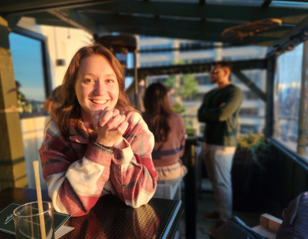 Allison Dobscha smiles for the camera on a rooftop during golden hour