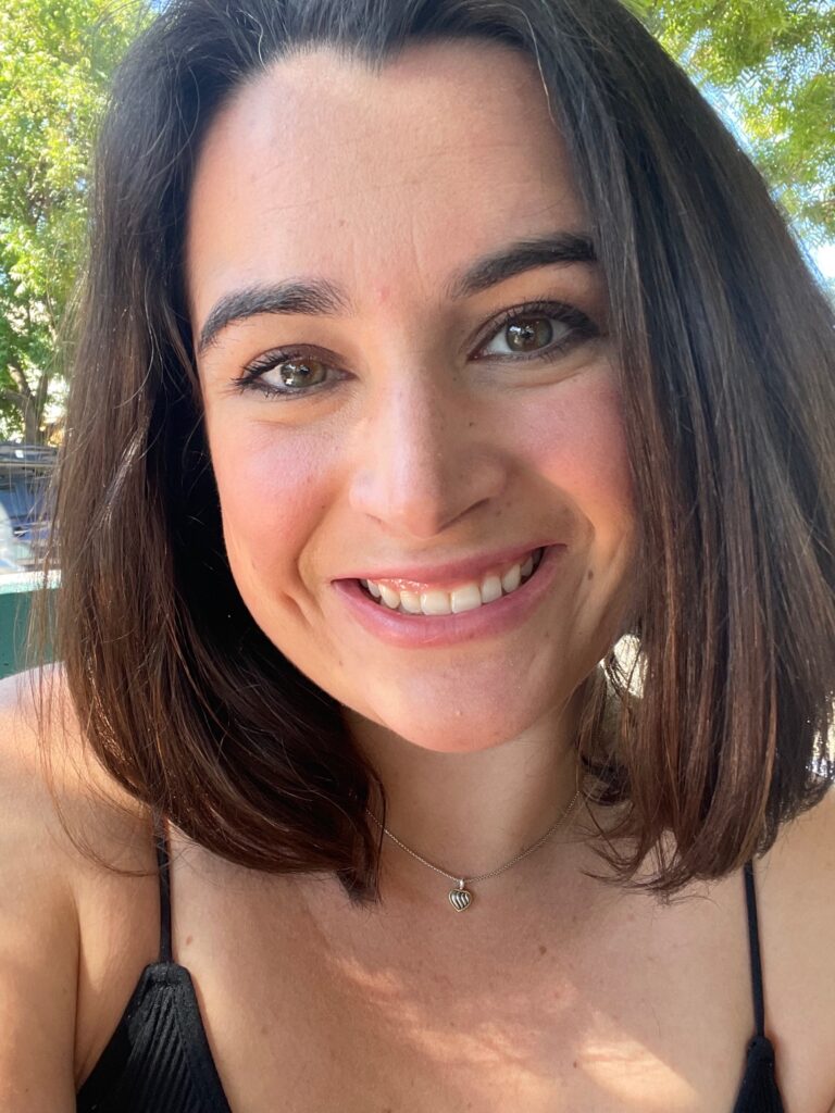 Honor Murphy smiles in a selfie in front of some overhanging trees