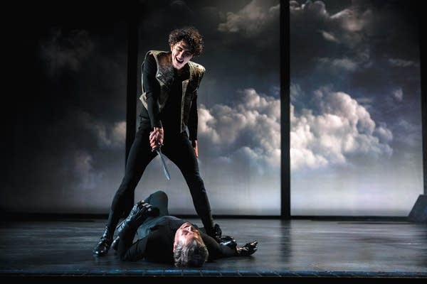 Macbeth actor standing over a body on stage at the Guthrie