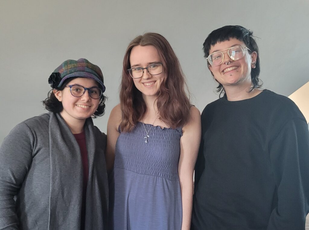 In this photo, MacSlams team members Shoshana Castro-Root and Riley Gaikowski stand next to their coach, Ollie Schminkey 