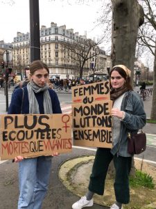 Elinor and a friend holding cardboard signs for 2020 Paris Women's March