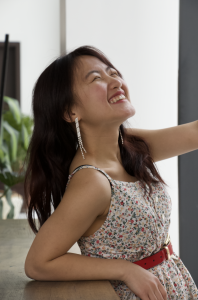 Student leans against a table and laughs