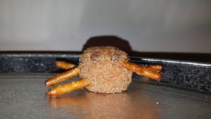 A donut hole with pretzel legs like a spider