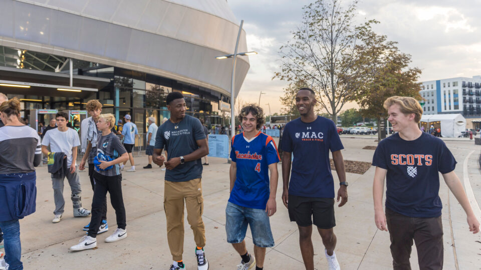 Four Macalester students walk past Allianz Field in St. Paul