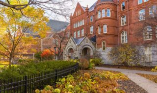 Old Main in the fall, surrounded by orange and yellow foliage.