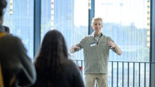An admissions counselor presents to a group of students.