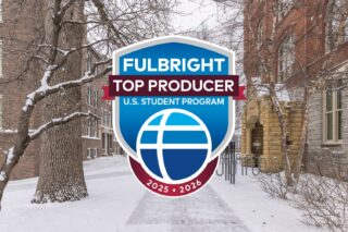 A snowy walkway on Macalester's campus is covered by a large blue badge that reads Fulbright Top Producers: U.S. Student Program 2025-2026