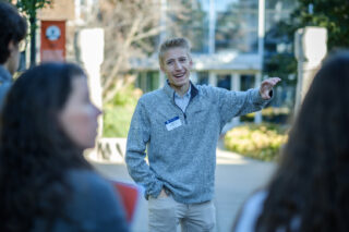 An admissions counselor presents to a group of students.