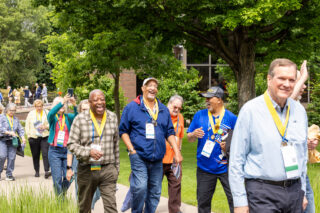 A group of Golden Scots laugh as they walk together across campus during Reunion.