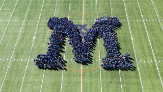 Drone camera shot of members of the Class of 2030 standing in an M shape on the football field